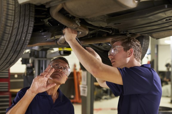 teacher and student working on car